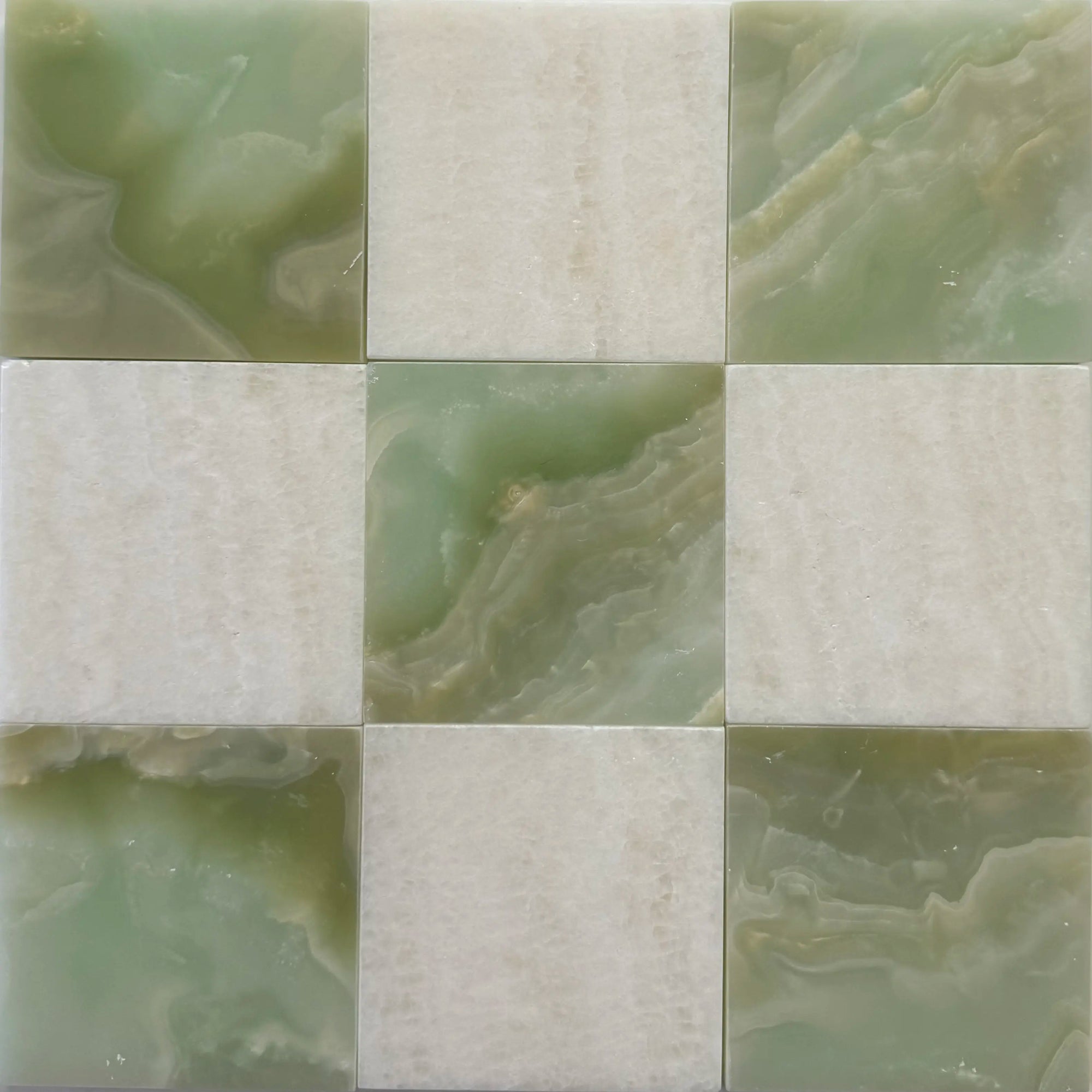 Close-up of checkerboard pattern featuring polished Green Onyx and Vanilla Onyx tiles. The green and beige hues create a harmonious blend, perfect for luxury tile installations in bathrooms or backsplashes. Natural stone tiles with a glossy finish highlight the onyx’s translucent beauty.